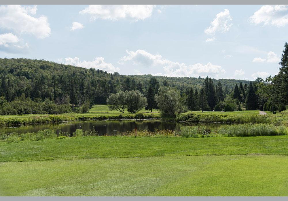 Étang entouré de verdure sur le parcours du Club de golf Val‑Morin.
